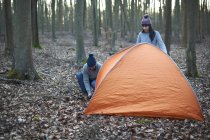Couple put up tent in woods — Stock Photo