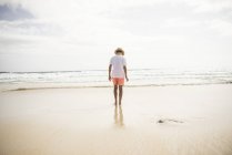 Niño caminando en la playa - foto de stock