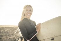 Mulher de fato de mergulho a preparar-se para surfar — Fotografia de Stock