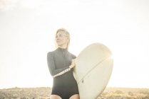 Mulher de fato de mergulho a preparar-se para surfar — Fotografia de Stock