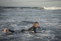 Man in wetsuit preparing to surf — Stock Photo