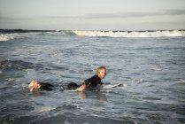 Homem de fato de mergulho a preparar-se para surfar — Fotografia de Stock