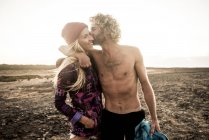 Hombre abraza novia en playa - foto de stock