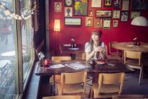 Женщина сидит в кофейне — стоковое фото