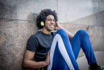 Hombre escuchando música a través de auriculares - foto de stock