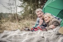 Pareja mayor divirtiéndose en camping - foto de stock