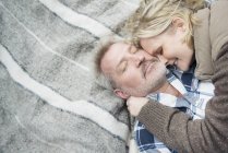 Seniorenpaar kuschelt auf Decke — Stockfoto