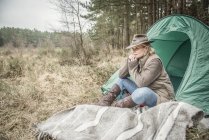Signora seduta godendo deserto dal campeggio — Foto stock