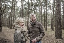 Пара смеется во время прогулки по лесу — стоковое фото