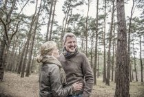 Casal rindo durante caminhada na floresta — Fotografia de Stock