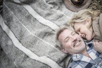 Seniorenpaar kuschelt auf Decke — Stockfoto