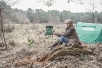 Dame sitzt und genießt Wildnis vom Campingplatz aus — Stockfoto