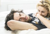 Влюбленная пара, лежащая в постели — стоковое фото