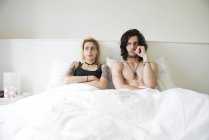 Пара, лежащая в двуспальной кровати после спора — стоковое фото