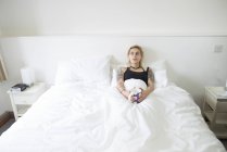 Женщина лежит в постели и наслаждается чашкой чая — стоковое фото