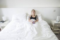 Frau liegt im Bett und genießt Tasse Tee — Stockfoto