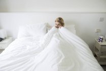 Woman in bed with duvet pulled up to chin — Stock Photo