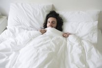 Mann liegt im Bett — Stockfoto
