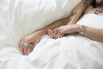 Пара тягне руки через ковдру — стокове фото