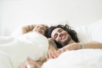 Пара смеющихся в постели — стоковое фото