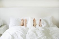 Feet sticking out from underneath covers — Stock Photo