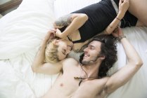 Tattooed couple lying together on bed — Stock Photo
