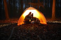 Couple sit in tent at night — Stock Photo