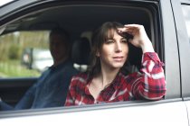Frau blickt wehmütig aus Autofenster — Stockfoto