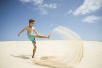 Мальчик играет в песчаных дюнах — стоковое фото