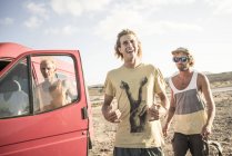 Surfistas masculinos em pé de carro — Fotografia de Stock