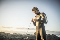 Homme en combinaison de plongée se préparant à surfer — Photo de stock