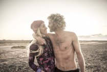 Man embraces girlfriend on beach — Stock Photo