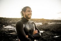 Homem de fato de mergulho fica na praia — Fotografia de Stock