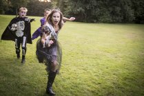 Дети гонятся за девочкой в костюме зомби — стоковое фото