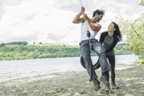Man and woman on tyre hanging from tree — Stock Photo