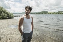 Uomo in giubbotto bianco in piedi sulla riva — Foto stock