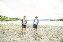 Two boys walking on shore — Stock Photo