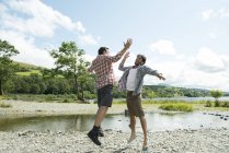Zwei Männer springen auf High Five — Stockfoto