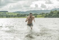 Mann läuft durch flaches Wasser — Stockfoto