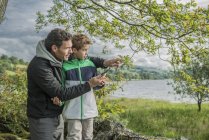 Man showing son how to use compass — Stock Photo