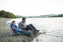 Father and son fishing from shore — Stock Photo
