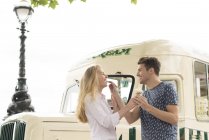 Couple standing in front of traditional ice cream van — Stock Photo