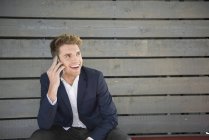 Man sitting on bench and making phone call — Stock Photo