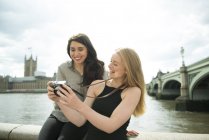 Two friends looking at photographs on South Bank — Stock Photo