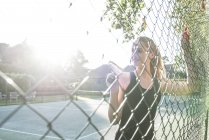 Woman leaning against fence — Stock Photo