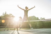 Жінка робить розтяжки на тенісному корті — стокове фото