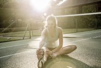 Жінка робить розтяжки на тенісному корті — стокове фото