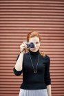 Frau mit klassischer Kamera vor Garagentor — Stockfoto