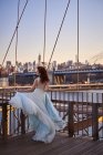 Mujer en vestido azul en el puente de Brooklyn - foto de stock