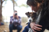 Homme prenant une photo de petite amie avec chien — Photo de stock